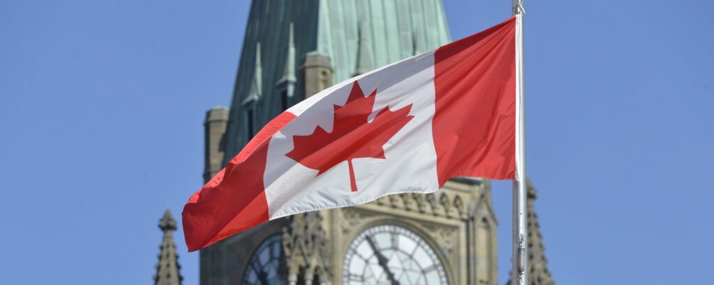 Canadian flag waving in front of Parliament Hill